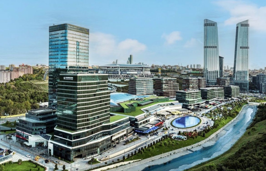 Aerial view of Vadistanbul, showcasing modern high-rise apartment buildings surrounded by lush greenery.